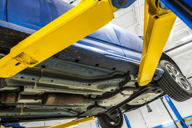 Damaged car underbody requiring inspection and repair at an auto body shop